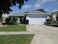 Charming single-story home featuring a well-maintained lawn and a two-car garage in a peaceful neighborhood at 2014 Corner Meadow Cir, Orlando, FL 32820