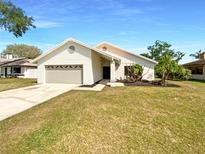 Charming single-story home with a well-manicured front lawn and attached two-car garage on a clear, sunny day at 2835 Abney Ave, Orlando, FL 32833