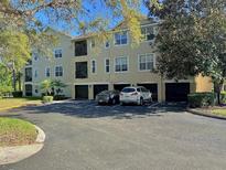 Three story condo building with attached garages in a paved parking lot at 413 Summit Ridge Pl # 115, Longwood, FL 32779
