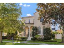 Charming two-story home with manicured lawn and covered porch with arched entry, enhanced by mature trees at 4474 Virginia Dr, Orlando, FL 32814