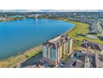 Stunning aerial view of a waterfront apartment building with lake and city skyline views at 8743 The Esplanade # 11, Orlando, FL 32836