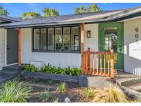 Attractive front entrance featuring fresh landscaping, wood accents, and a stylish green door at 905 W 11Th Ave, Mount Dora, FL 32757