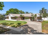 Inviting single-story home featuring stone accents, a well-manicured lawn, and a spacious driveway at 9109 Galleon Dr, Orlando, FL 32819