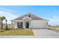 Charming single-Gathering home with a well-manicured lawn and a cozy front porch seating area at 101 Kayak Ave, Haines City, FL 33844