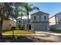 Charming two-story home with a well-manicured lawn and beautiful palm trees enhancing its curb appeal at 13545 Fox Glove St, Winter Garden, FL 34787