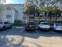 Exterior view of a parking lot with various cars parked in front of a residential building with palm trees at 13929 Fairway Island Dr # 822, Orlando, FL 32837