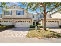 Charming townhome with a two-car garage, brick paver driveway, and attractive landscaping at 1613 Priory Cir, Winter Garden, FL 34787