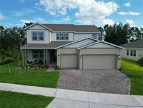 Attractive two-story home featuring a three-car garage and a beautifully landscaped front yard at 3036 Country Side Dr, Apopka, FL 32712