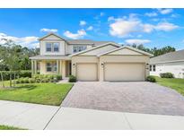 Charming two-story home with manicured lawn, brick driveway, and a spacious three-car garage at 3036 Country Side Dr, Apopka, FL 32712