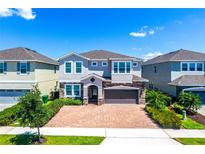 Charming two-story home with brick driveway, beautiful stone accents and well-manicured lawn at 7463 Marker Ave, Kissimmee, FL 34747