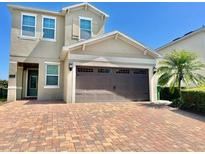 Charming two-story house featuring a brick driveway, neutral paint, and a two-car garage at 7479 Marker Ave, Kissimmee, FL 34747