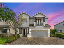 Charming two-story home with a two car garage and balcony, complemented by a brick driveway at 7483 Marker Ave, Kissimmee, FL 34747