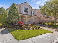 Beautiful two-story home with well-manicured lawn, vibrant landscaping, and an attached two-car garage at 8312 Fontera Dr, Davenport, FL 33896