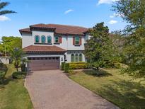 Beautiful two-story home with a tile roof, brick driveway, and lush green lawn at 8531 Geddes Loop, Orlando, FL 32836