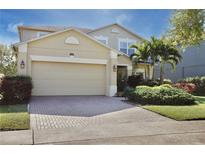 Charming two-story home with a brick driveway, two-car garage, and well-maintained landscaping at 9149 Oak Commons Way, Orlando, FL 32832