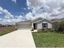 Charming single-story home with a well-manicured lawn and a convenient two-car garage at 945 Laurel View Way, Groveland, FL 34736