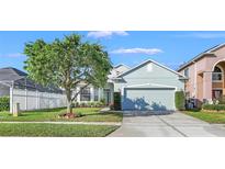 Charming single-Gathering home featuring a well-manicured lawn, mature trees, and a two-car garage at 1318 Horizon Creek Ct, Orlando, FL 32828