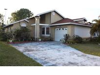 Charming single-story home with a well-maintained front yard and a private two-car garage at 165 Coralwood Cir, Kissimmee, FL 34743