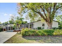 Charming single-story home with well-maintained landscaping and a covered carport on a sunny day at 2012 Dorris Dr, Orlando, FL 32807