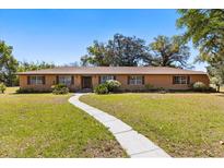 Charming brick home with a well-manicured lawn and inviting walkway leading to the front door at 209 Camden Rd, Altamonte Springs, FL 32714