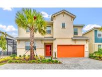 Inviting two-story home featuring a vibrant orange garage door and a lush palm tree in the front yard at 2557 Shanti Dr, Kissimmee, FL 34746