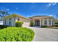 Charming home featuring a stucco exterior, arched entryway, manicured landscaping, and a spacious driveway at 3227 S Crystal Lake Dr, Orlando, FL 32806