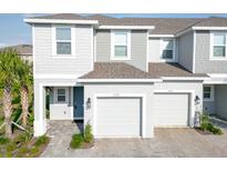 Charming two-story townhome featuring a gray exterior, attached garages and a cozy front yard at 3339 Whooping Crane Dr, Davenport, FL 33837