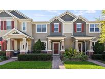 Charming townhome featuring a well-manicured lawn and inviting entryway at 652 Orange Belt Loop, Winter Garden, FL 34787