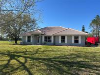 Charming single-story home with a well-manicured lawn and neutral colors that offer a warm and inviting feel at 7847 Golf Paradise Way, Clermont, FL 34711