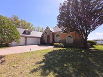 Charming home featuring stone accents, a tile roof, arched windows, and a well-manicured lawn at 9137 Southern Breeze Dr, Orlando, FL 32836