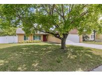 Charming single-story home with a well-maintained lawn and mature tree providing shade in the front yard at 1045 Dishman Loop, Oviedo, FL 32765
