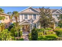 Charming two-story townhome featuring a well-manicured lawn and inviting covered entryway at 14433 Pleach St, Winter Garden, FL 34787