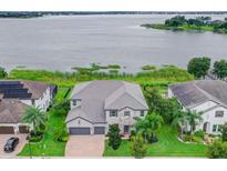 Stunning lakefront home with lush landscaping, stone accents, and a three-car garage at 16689 Broadwater Ave, Winter Garden, FL 34787