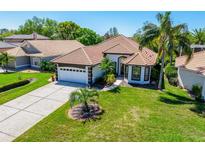Inviting single-story home featuring a well-manicured lawn, tile roof, and an attached two-car garage at 4104 Willow Bay Dr, Winter Garden, FL 34787