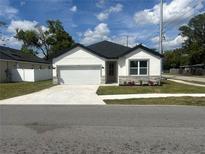 Charming single-story home with a well-manicured lawn and a concrete driveway at 493 E Palmetto Ave, Longwood, FL 32750
