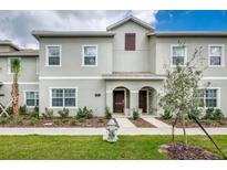 Inviting townhome with a well-maintained lawn and charming architectural details at 4962 Windermere Ave, Kissimmee, FL 34746