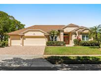 Charming single-Gathering home with manicured lawn and a brick paved driveway leading to a three car garage at 10337 Pointview Ct, Orlando, FL 32836