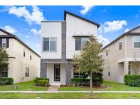 Striking modern two-story home with stone accents, landscaping, and contemporary design at 10372 Austrina Oak Loop, Winter Garden, FL 34787