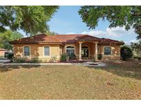 Charming stucco home featuring a red tile roof, manicured landscaping, and a welcoming front entrance at 11108 Rockport St, Orlando, FL 32836