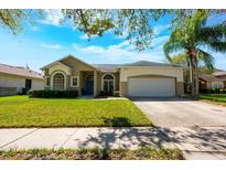 Charming single-Gathering home features a well-manicured lawn, attached garage, and a welcoming blue front door at 13552 Dornoch Dr, Orlando, FL 32828