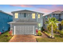 Charming two-story home with a well-manicured lawn and an illuminated brick driveway at twilight at 3964 Lightning Ct, Sanford, FL 32773