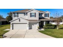 Charming two-story home featuring a three-car garage and well-maintained landscaping at 420 Lone Heron Way, Winter Garden, FL 34787