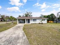 Charming single-story home with a covered carport and a well-maintained front yard and long concrete driveway at 46 Morning Glory Dr, Debary, FL 32713