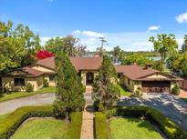 Stunning lakefront home with mature landscaping, circular driveway, and attached two-car garage at 5400 Kenmore Ln, Orlando, FL 32839