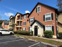 Charming two-story condo building with black shutters, a private entrance, and well-maintained landscaping at 6071 Westgate Dr # 324, Orlando, FL 32835