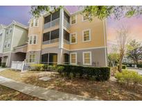 Beautiful three-story condo with yellow siding, white trim, and screened in patios at 6412 Queens Borough Ave # 215, Orlando, FL 32835