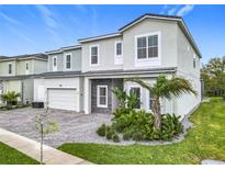 Beautifully landscaped home featuring a two-car garage and a combination of stone and stucco finishes at 1739 Oak Blossom Dr, Davenport, FL 33837