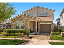 Charming two-story home showcasing a stone facade, well-manicured lawn, and a welcoming, covered entryway at 1832 Sandy Park Trl, Kissimmee, FL 34747