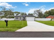 Charming single-story home with a well-manicured lawn and a two-car garage at 2341 Oleander Rd, Deland, FL 32724