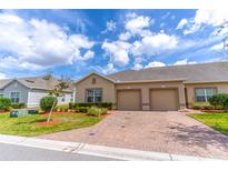 Charming single-story home featuring a brick driveway, two-car garage, and manicured landscaping at 2833 Attwater Loop, Winter Haven, FL 33884